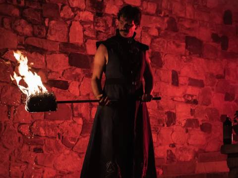 L'alchimista di Athanor illuminato di rosso a Medioevo a la Rocca, Rocca San Felice 2023