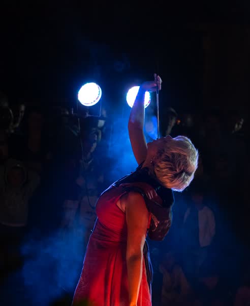 La performer di spalle fra le luci di scena, Athanor al Mojoca 2023
