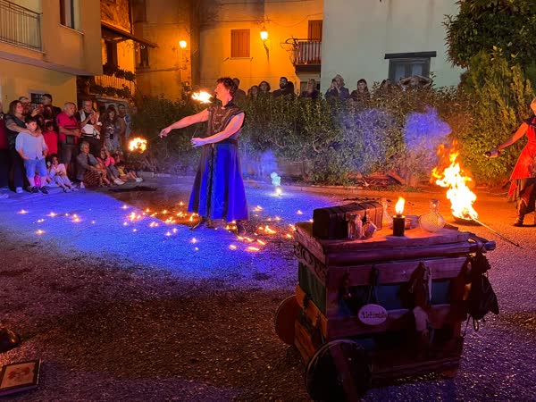 Il pubblico intorno al fuoco nella piazza del borgo, Mojoca 2023