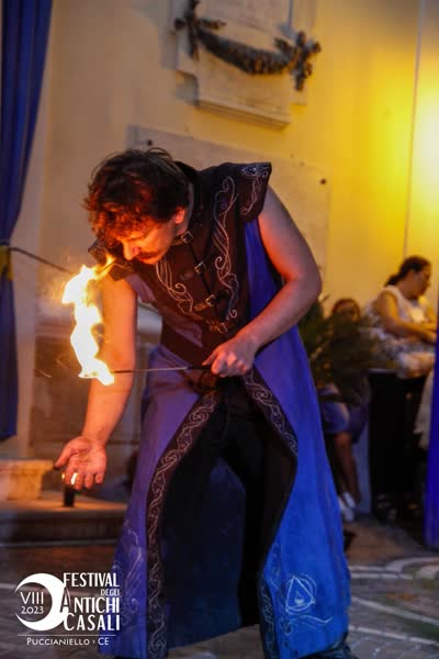 Alessandro con le bacchette da mangiafuoco accese vicino al viso, Festival degli Antichi Casali 2023