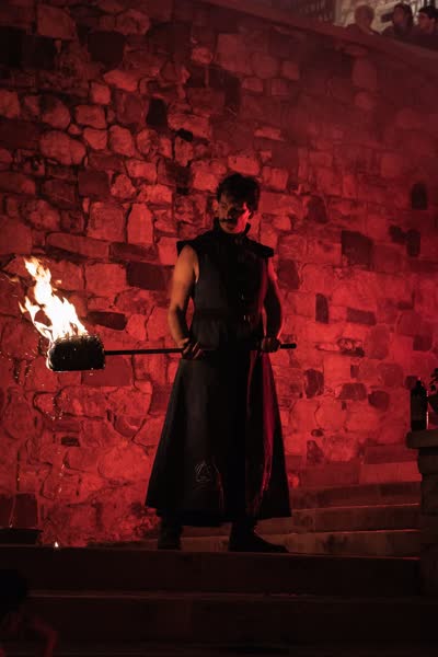 L'alchimista nella luce rossa contro il muro in pietra, Athanor a Medioevo a la Rocca 2023
