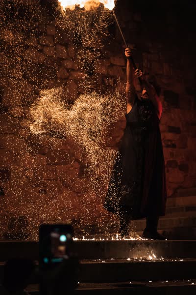Pioggia di scintille sopra la performer, Athanor a Medioevo a la Rocca 2023