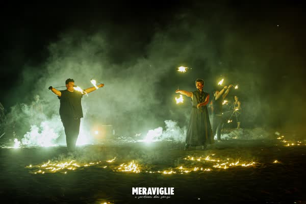 Due performer con il fuoco sulla spiaggia di Atrani, Meraviglie 2023