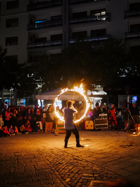 Alessandro manipola l'Hoopstaff, il grande cerchio di fuoco, davanti al pubblico, Il Crocifisso Ritrovato, Salerno 2025
